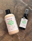 Two bottles of 'Patchouli Zest' products by Banyo on a textured surface