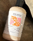 Bottle of banyo Petal Woods Aromatic Body Wash on a stone surface