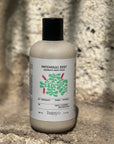 Bottle of Patchouli Zest Aromatic Body Wash by banyo on a stone surface with a natural background