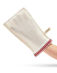 Beige bath mitt with red trim held by a hand on a white background