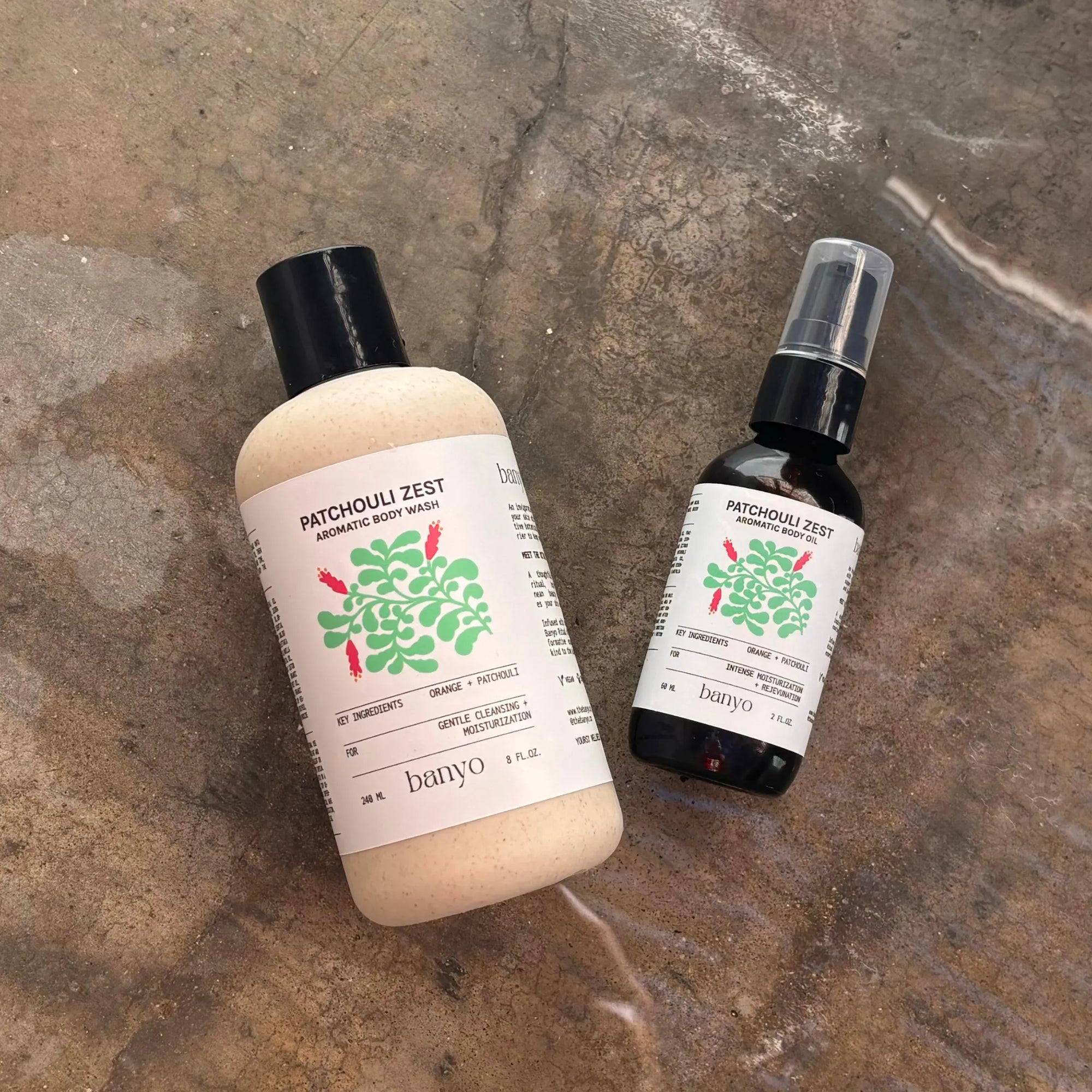 Two bottles of 'Patchouli Zest' products by Banyo on a textured surface