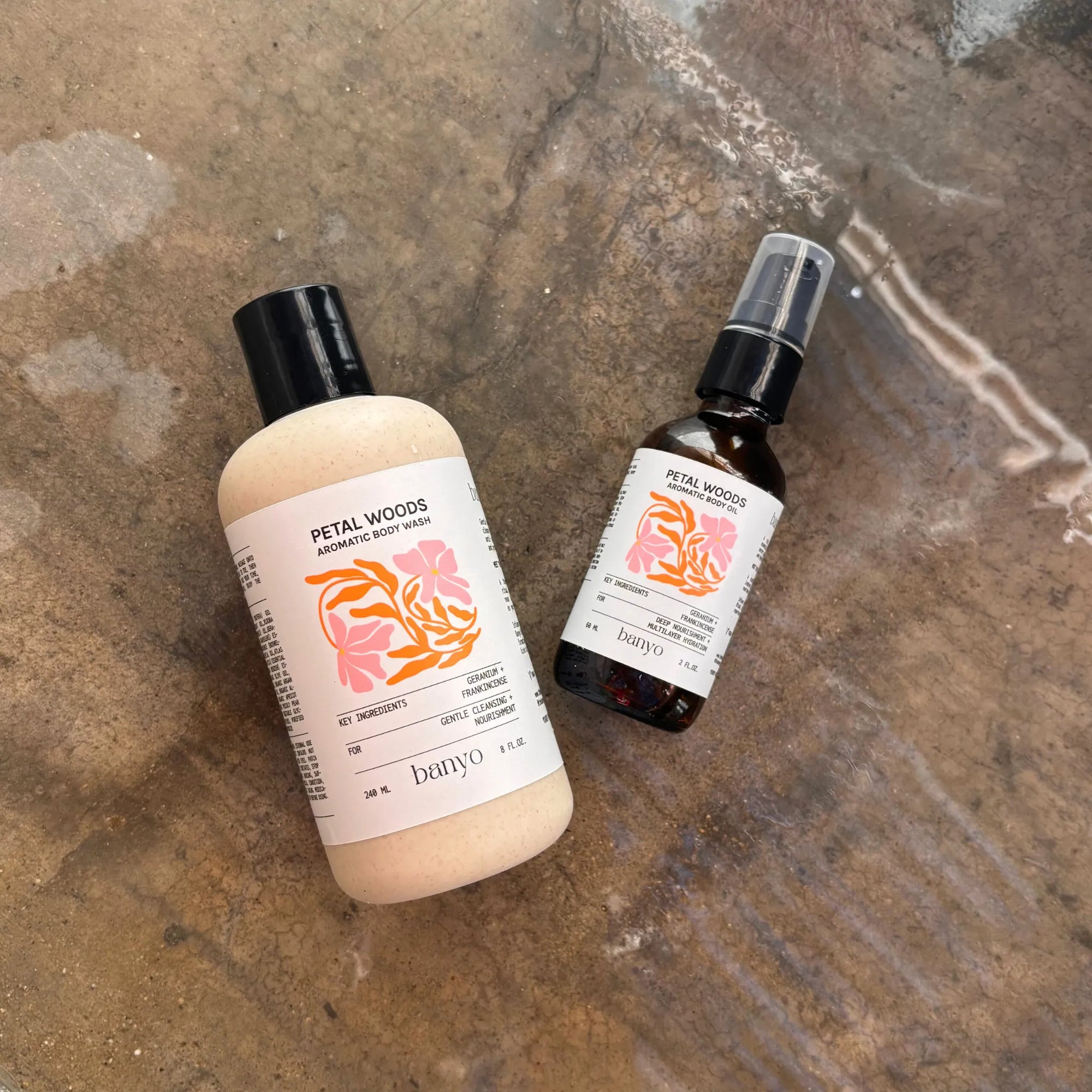 Two bottles of Petal Woods products on a textured surface