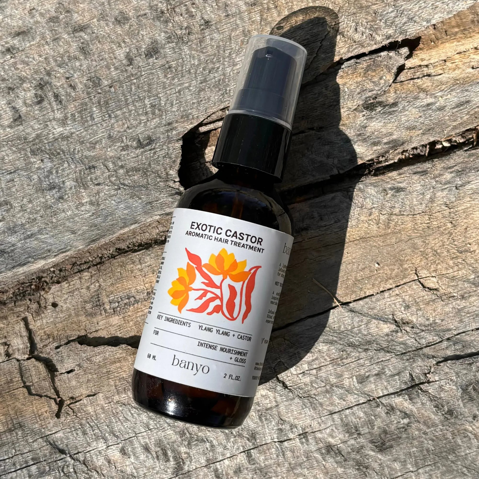 Bottle of Exotic Castor aromatic hair treatment on a wooden surface