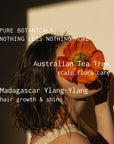 Person holding a red flower with text about Australian Tea Tree and Madagascar Ylang-Ylang products.