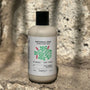 Bottle of Patchouli Zest Aromatic Body Wash by banyo on a stone surface with a natural background