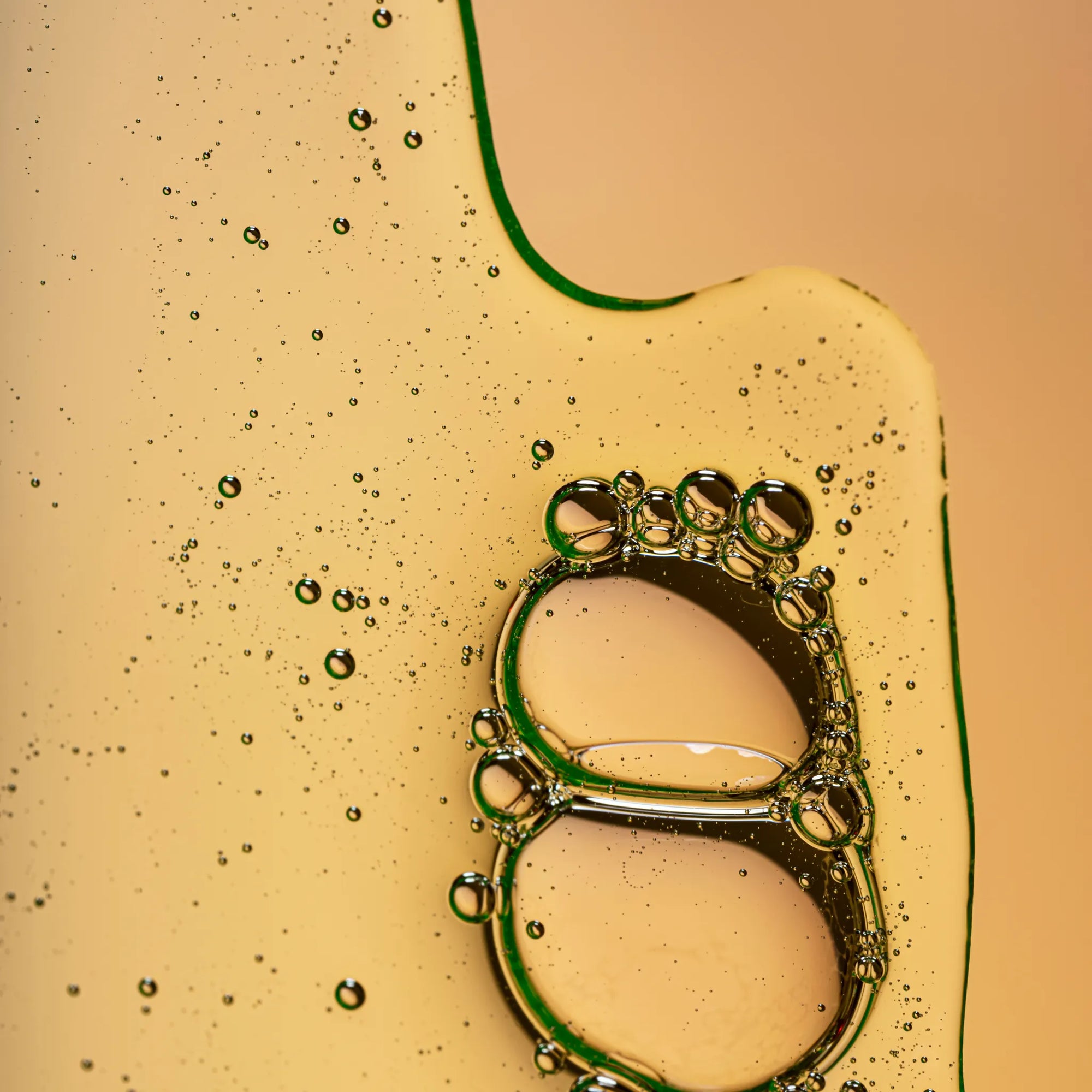 Close-up of a green bottle cap with bubbles on a beige background