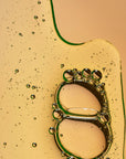 Close-up of a green bottle cap with bubbles on a beige background