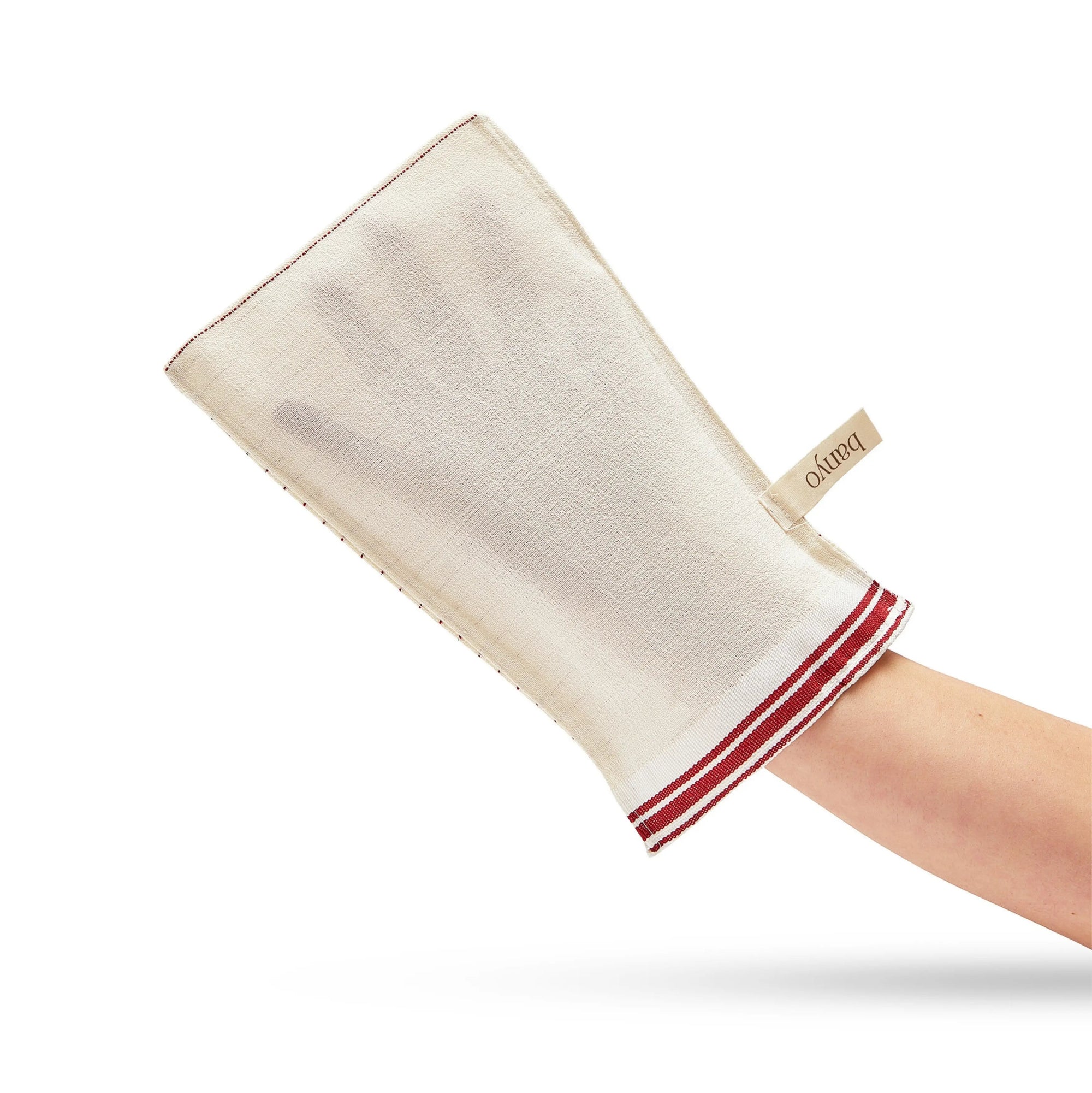 Beige bath mitt with red trim held by a hand on a white background