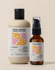 Two bottles of Petal Woods Aromatic Body Wash and Oil by banyo on a beige background