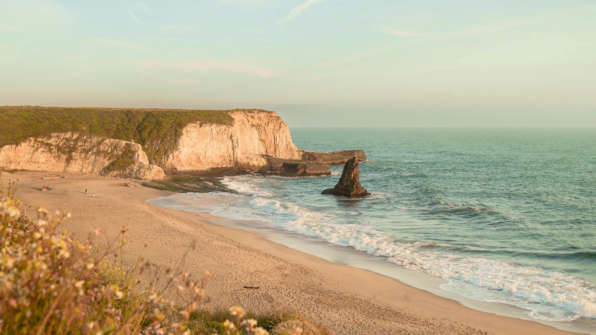 Beach with cliffs and ocean at sunset