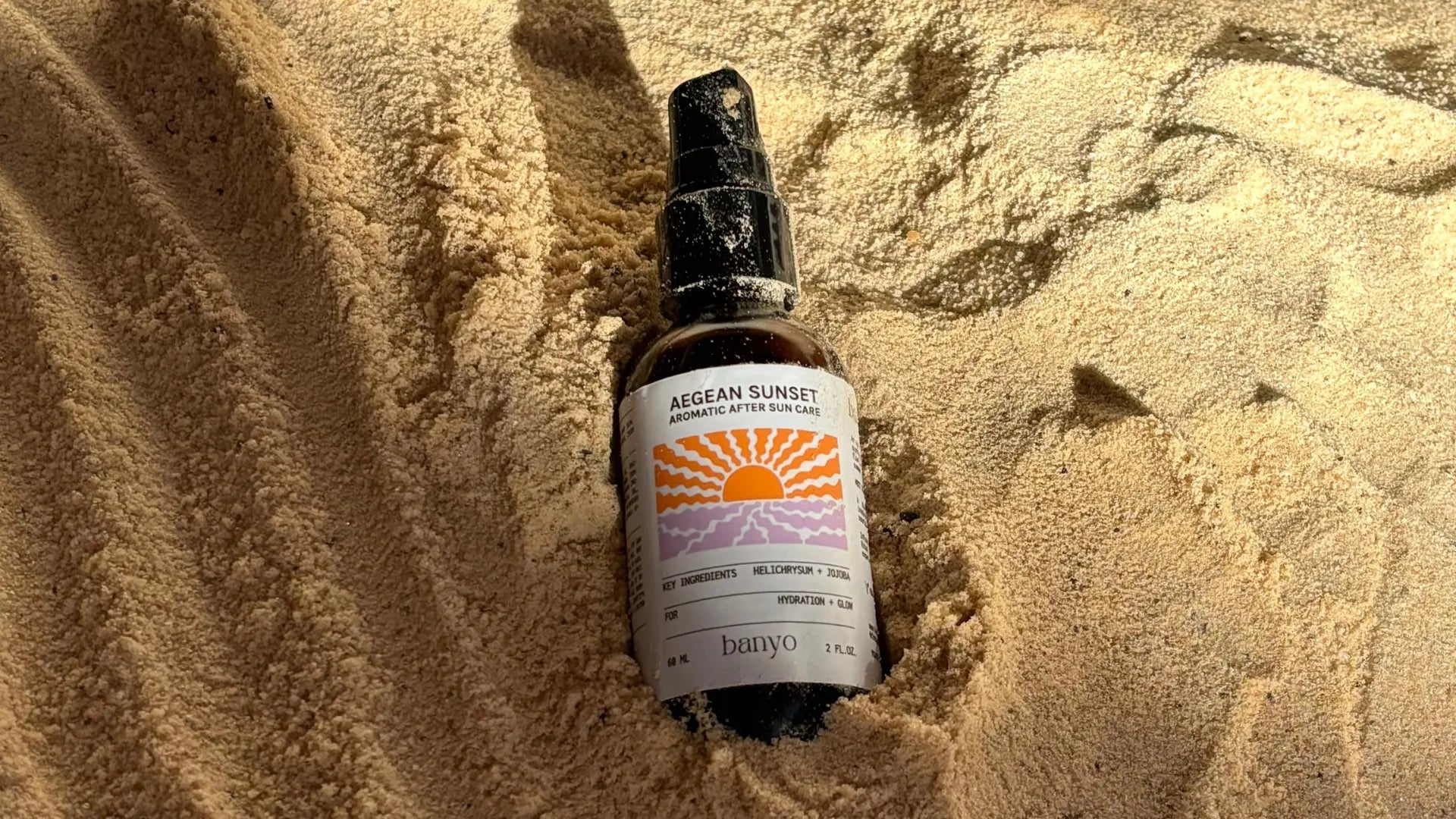 Bottle of 'Aegean Sunset' on sand